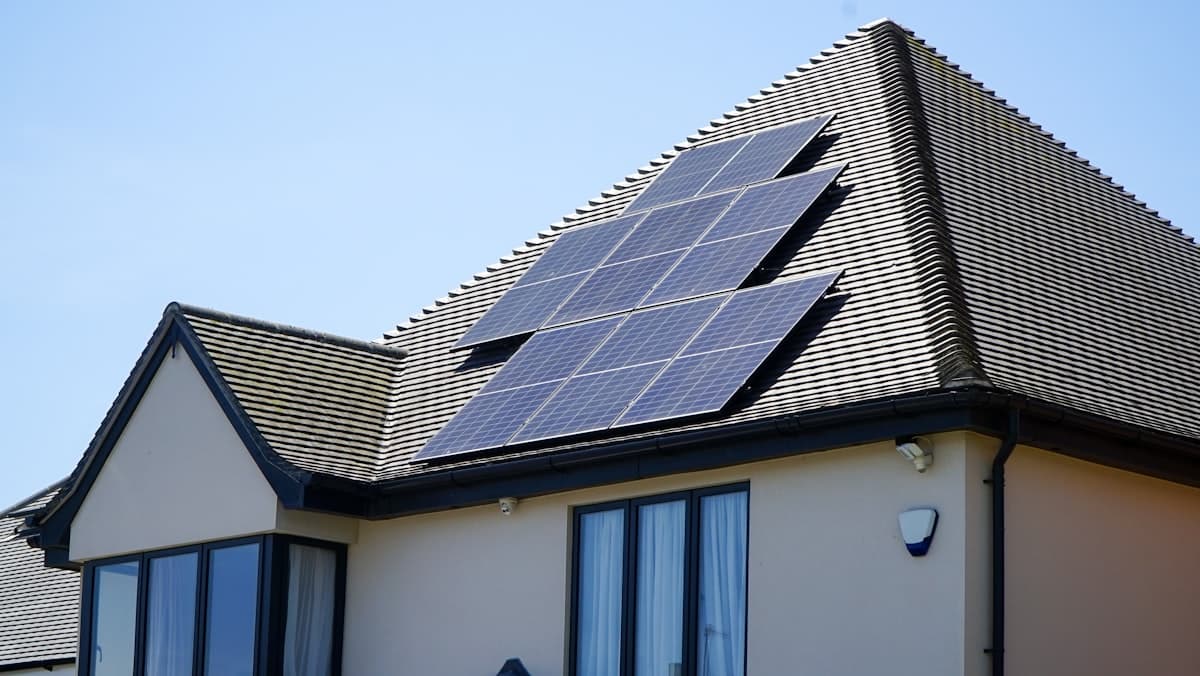 Solar panels installed on a residential rooftop under a bright blue sky